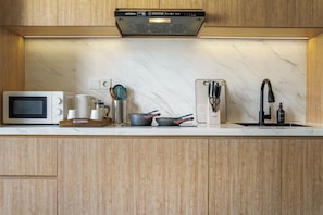 A modern kitchen with a built-in microwave, kettle, toaster, and sink. - Naya by Kozystay - Nusa Dua (Kuta)