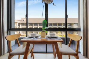 A dining table with two chairs, a potted plant, and a bowl set for two. - Naya by Kozystay - Nusa Dua (Kuta)