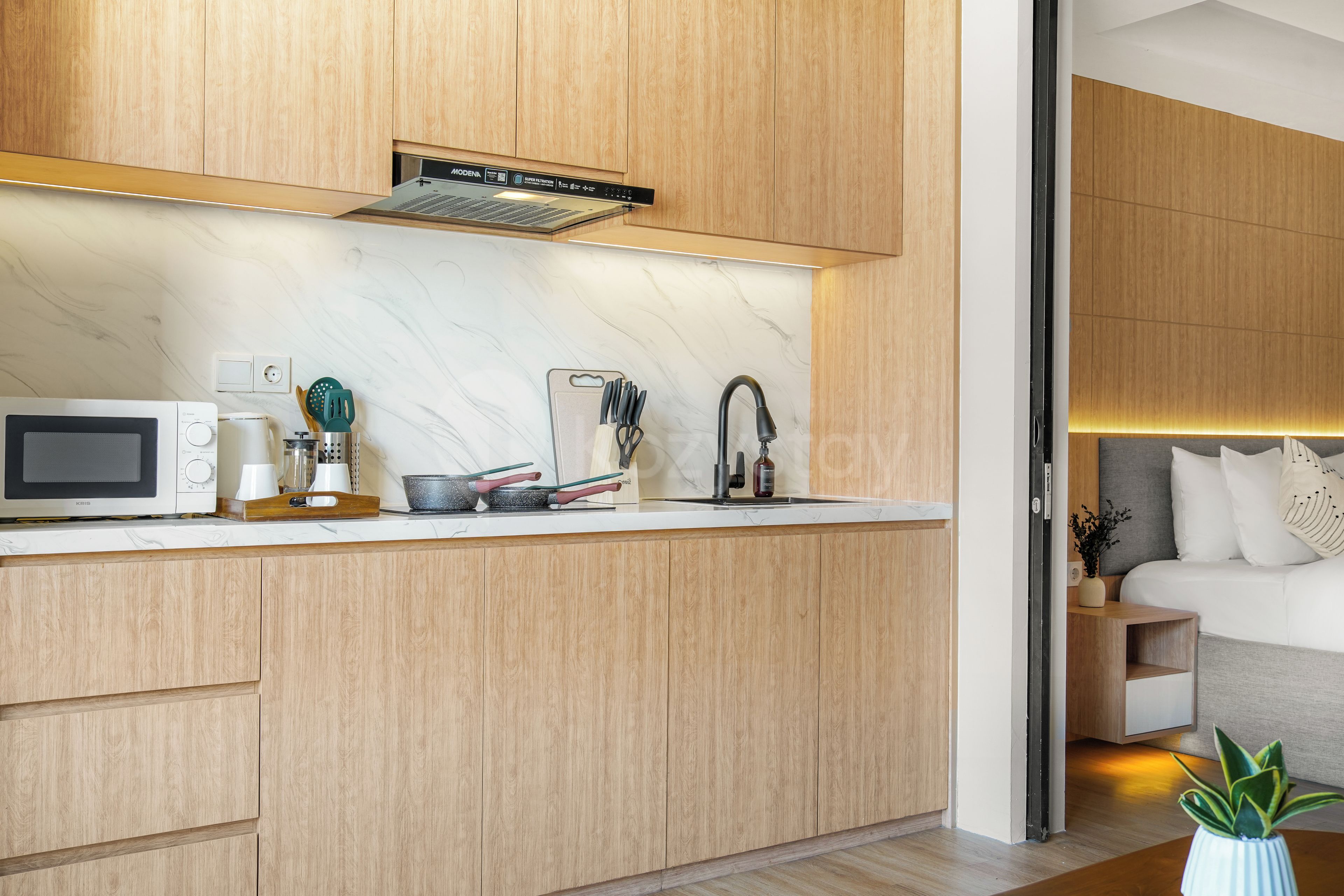 A modern kitchen with wooden cabinets, a built-in microwave, and a stainless steel faucet.