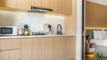 A modern kitchen with wooden cabinets, a built-in microwave, and a stainless steel faucet.
