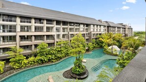 A hotel with a pool surrounded by lush greenery and a clear blue sky. - Naya by Kozystay - Nusa Dua (Kuta)