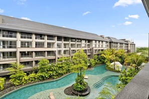 A hotel with a pool surrounded by lush greenery and a clear blue sky. - Naya by Kozystay - Nusa Dua (Kuta)