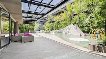 Ein moderner Poolbereich im Innenbereich mit Glasdach, Liegebereichen und einer Wandmalerei.