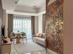 Ein modernes Wohnzimmer mit Essbereich, einer Couch und einem großen Fenster mit Vorhängen.