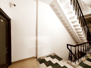 A staircase with a black railing and a white wall.