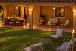 An outdoor patio with a dining table set for four, surrounded by chairs. There are two sofas and a small table with a candle. - Capovillas - Silent Country House (Gasponi)