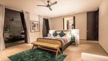 Un dormitorio moderno con cama, banca, ventilador de techo, mesita de noche y espejo.