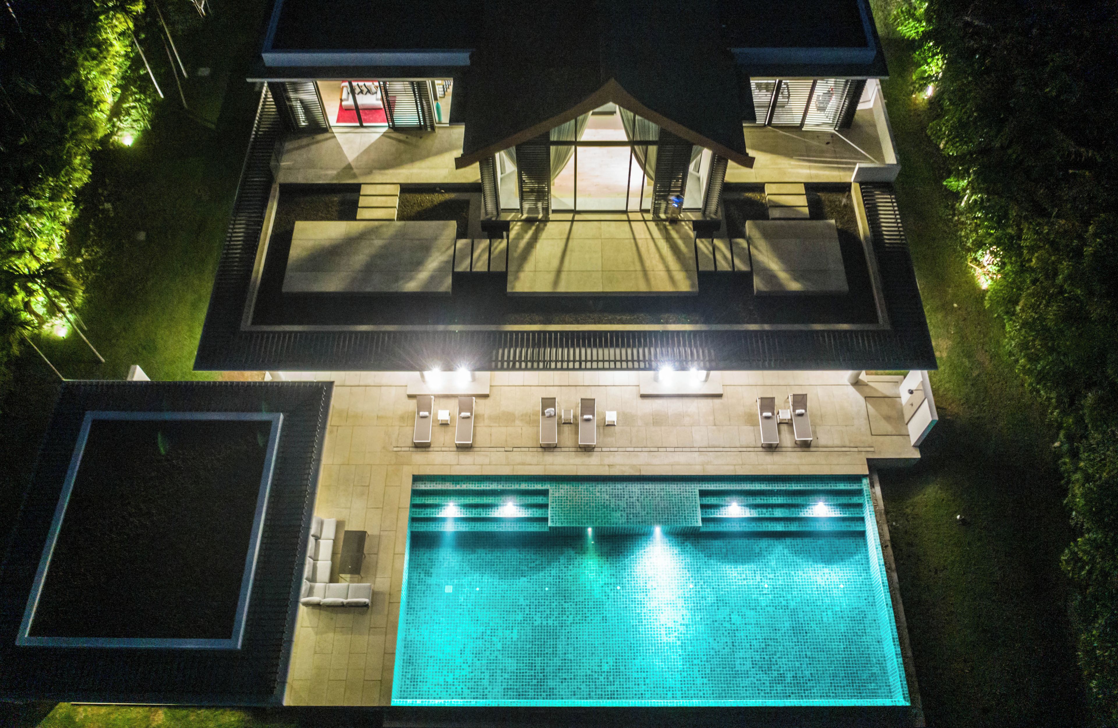 Un bâtiment à deux étages doté d’une piscine, d’un espace extérieur aménagé et d’une zone couverte.