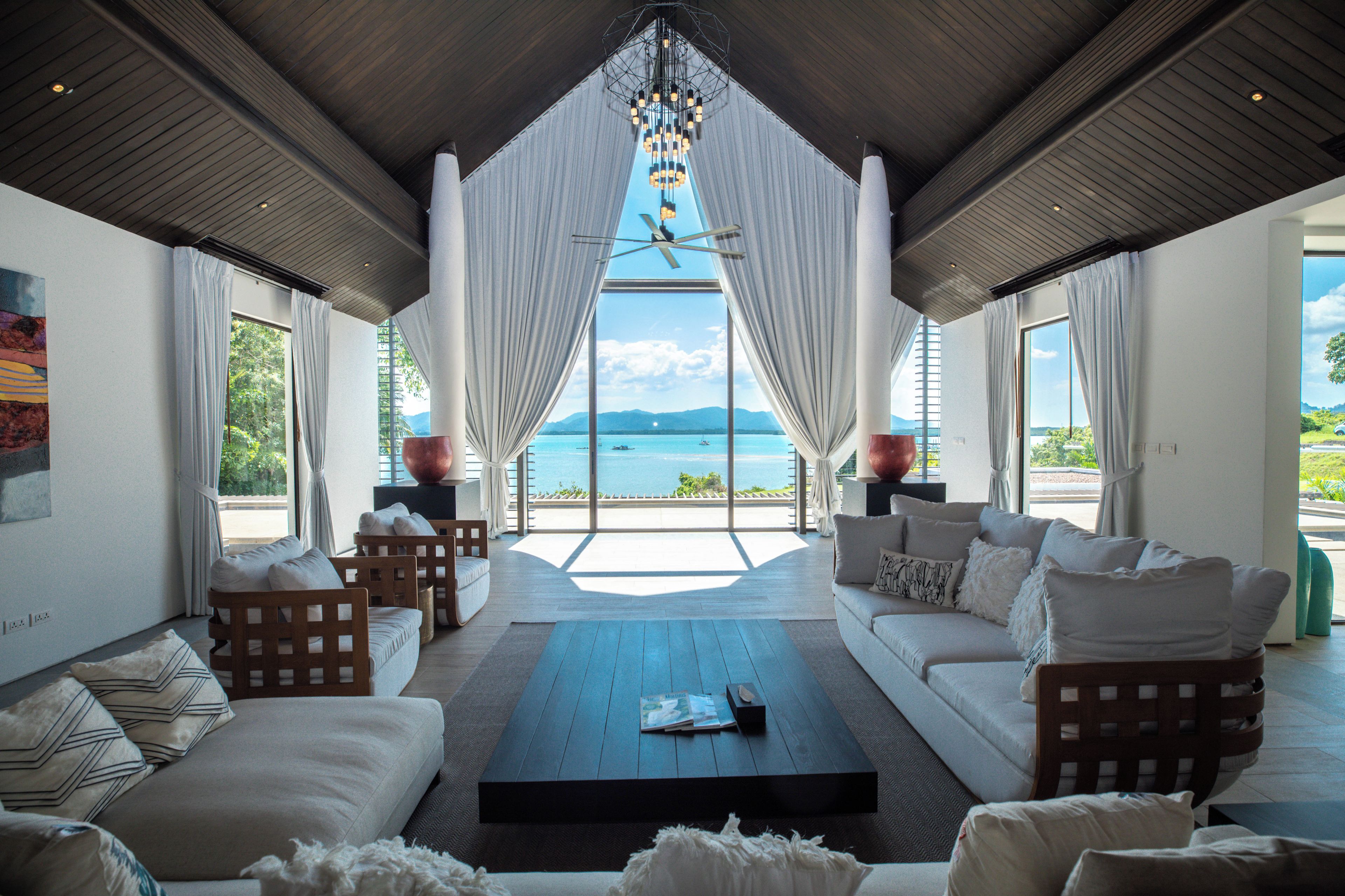 A spacious living area with a large window offering a view of the sea and mountains.