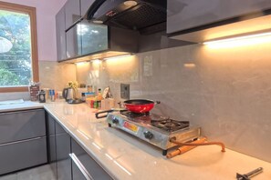 Una cocina moderna con estufa a gas, electrodomésticos de acero inoxidable y ventana que proporciona luz natural.