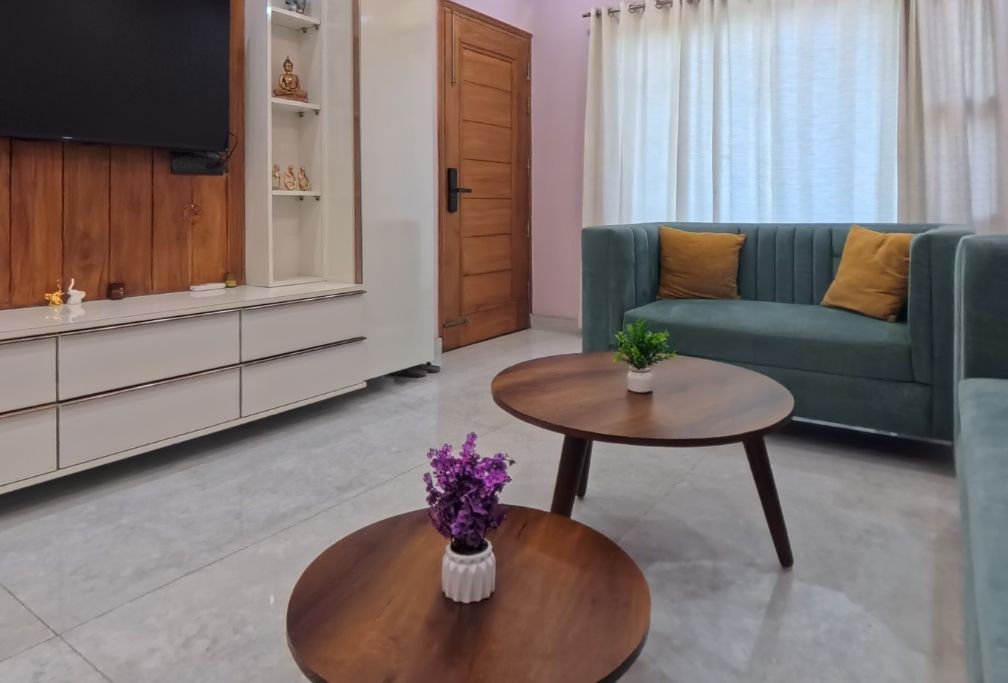 Una sala de estar con un sofá, una mesa de centro con una planta, un televisor y un armario.