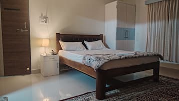 Une chambre à coucher comprenant un lit, une table de chevet, une lampe, une armoire et un tapis à motifs.