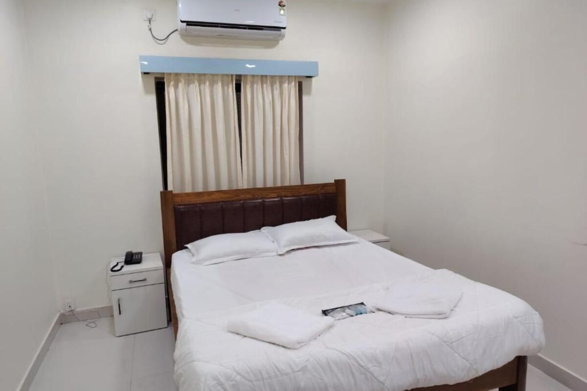 Une chambre d’hôtel équipée d’un lit, d’une table de chevet et d’un appareil de climatisation.