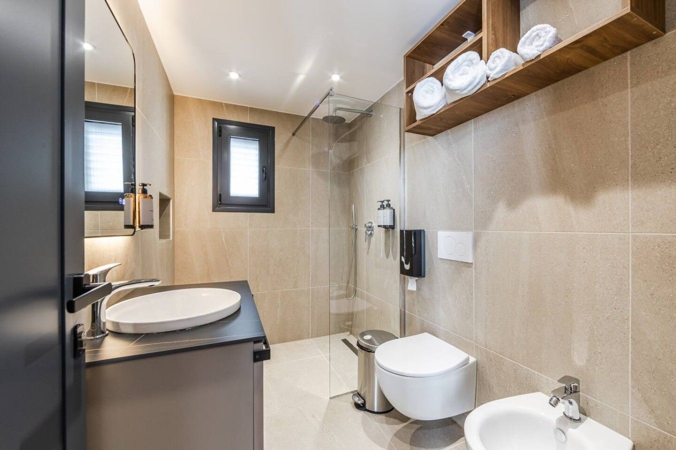 Un baño moderno con lavabo, inodoro, bidé y ducha.