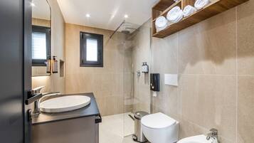 Un baño moderno con lavabo, inodoro, bidé y ducha.
