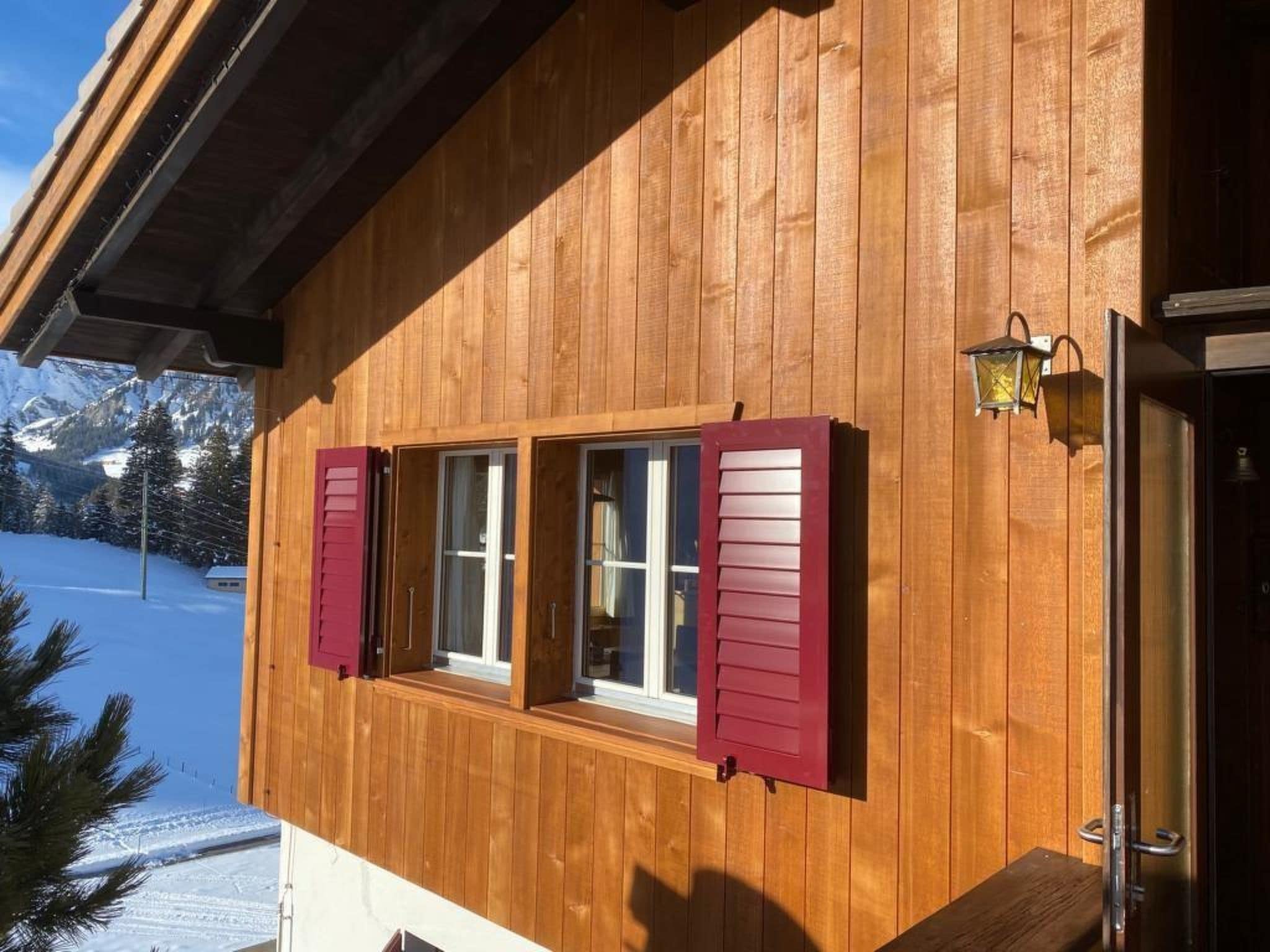 A wooden building with two windows, a door, and a small porch.