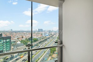 A cityscape view from a high-rise building with multiple lanes of traffic and a clear sky. - Galini by Kozystay - Tebet (South Jakarta)