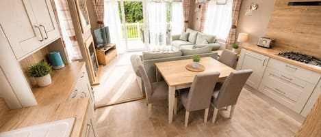 A compact kitchen with a dining area, a sofa, and a TV.