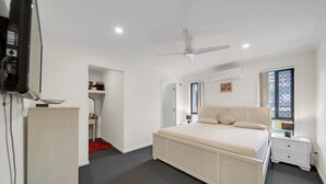 A bedroom with a large bed, a ceiling fan, a TV, and a small desk. - Entire 4BR Logan Hidden Gem w/ Pool Near Tamborine (Yarrabilba)