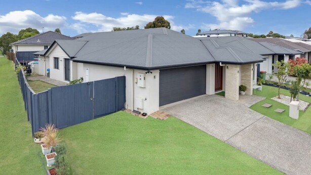 A residential property with a garage, a fenced yard, and a well-maintained lawn. - Entire 4BR Logan Hidden Gem w/ Pool Near Tamborine (Yarrabilba)