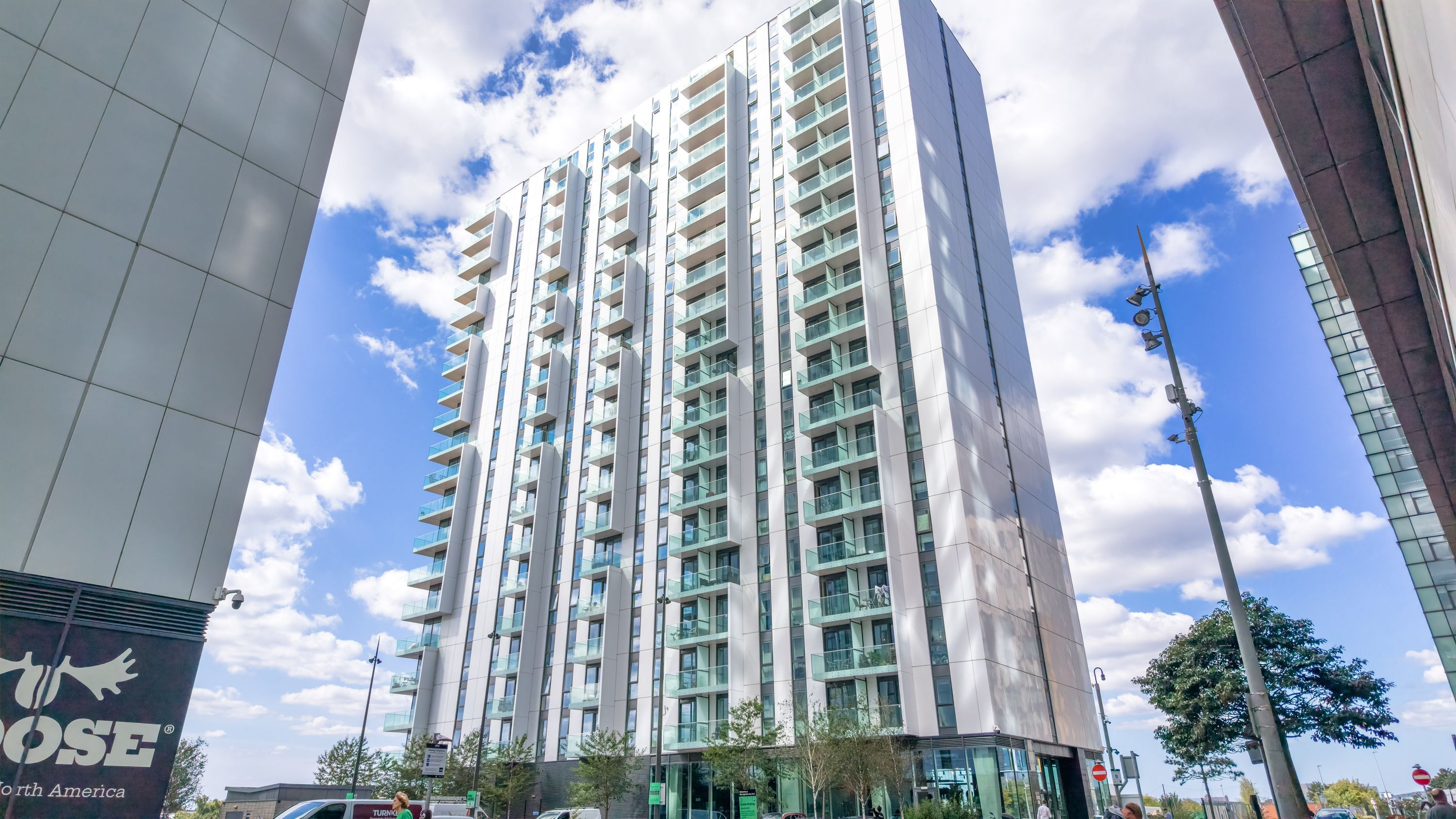A high-rise building with multiple balconies, a clear sky, and a sign for a hotel named 'TOth America'.
