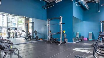 A gym with exercise equipment, a weight rack, and a view of the outside.