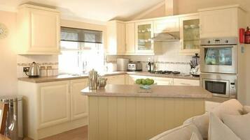 A kitchen with a central island, white cabinetry, and stainless steel appliances.