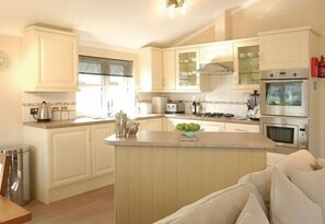 A kitchen with a central island, white cabinetry, and stainless steel appliances.