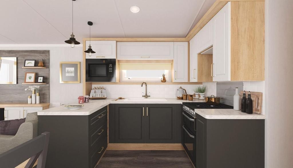 Una cucina moderna con mobili scuri, un piano di lavoro bianco e un forno a microonde integrato.
