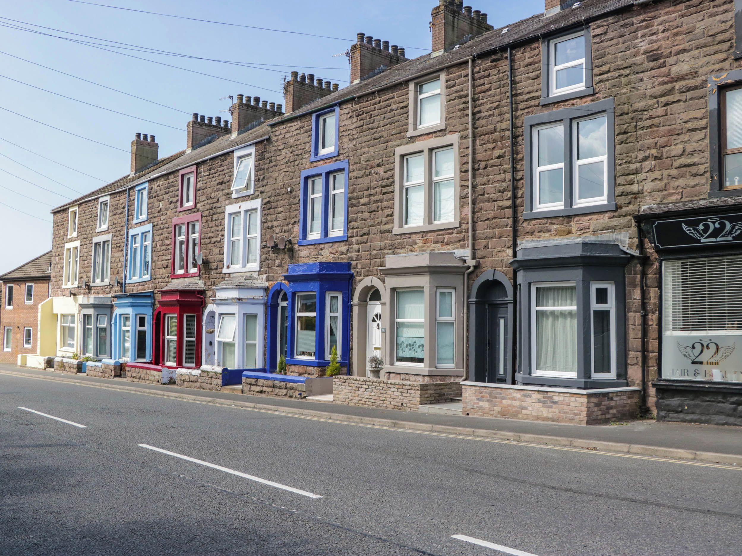A row of terraced houses with distinct architectural styles and varying window designs.