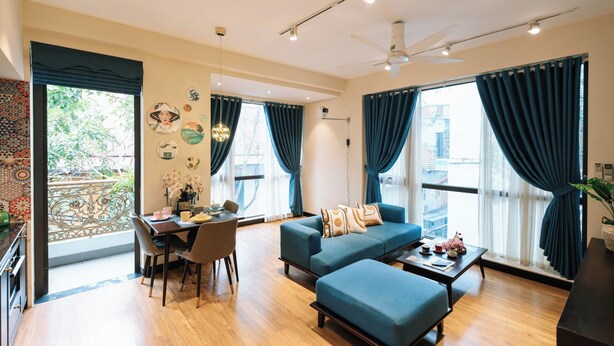 Ein modernes Wohnzimmer mit einer Couch, einem Hocker und einem Esstisch.