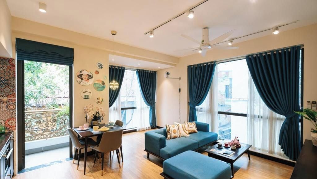 Een moderne woonkamer met een bank, een eettafel en een plafondventilator.
