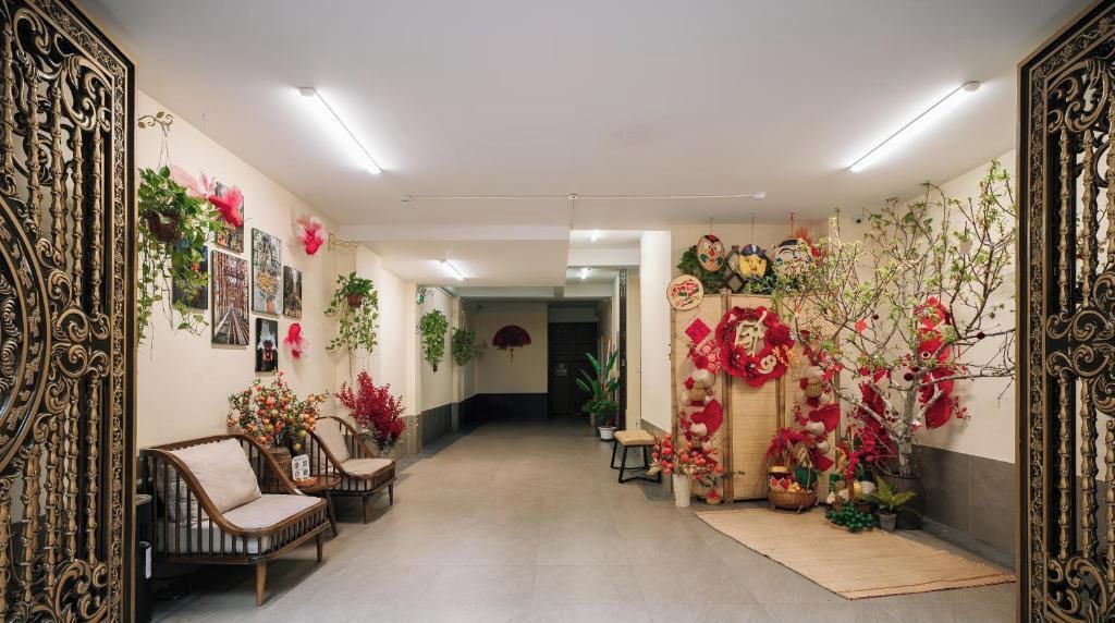 Un pasillo con un sofá, sillas y plantas decorativas.