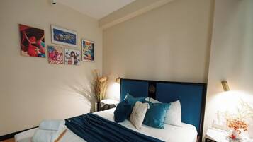 A hotel room with a bed, wall art, and a nightstand with a lamp.