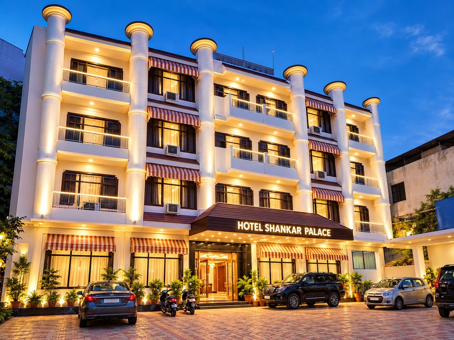 A multi-story hotel with a prominent entrance, multiple balconies, and a well-lit facade.