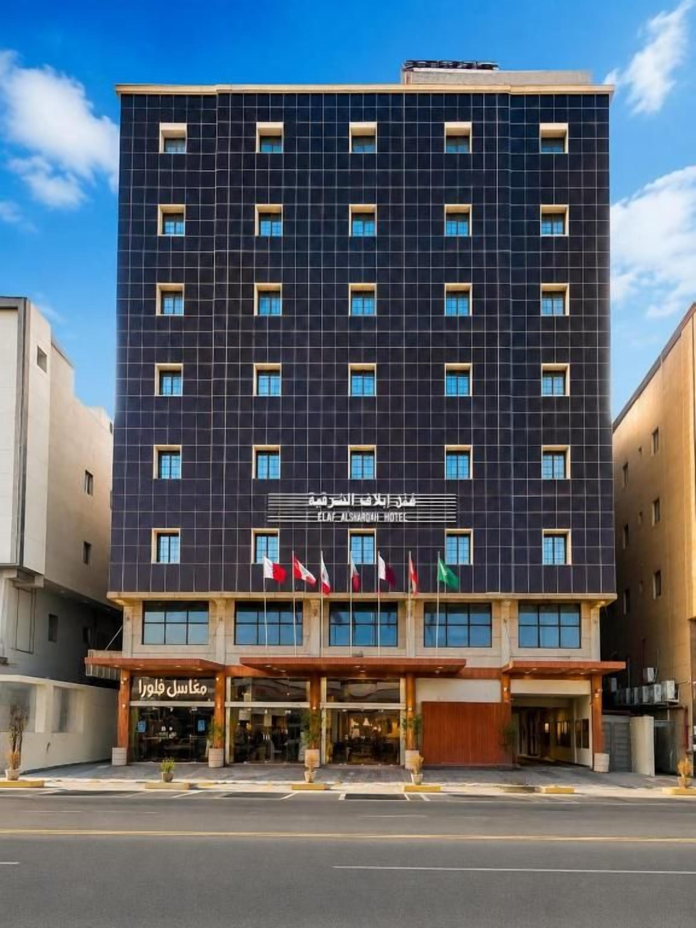 Un hotel de varios pisos con fachada oscura y numerosas ventanas.