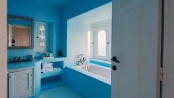 Un baño con techo azul, una bañera, un lavabo y una puerta.