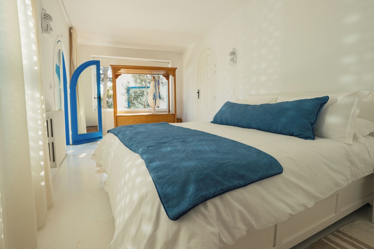 Un dormitorio con cama, ventana y puerta.