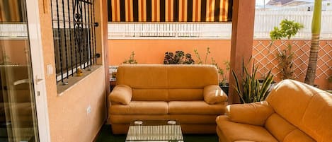 A cozy living area with a sofa, a coffee table, and a patterned wall.