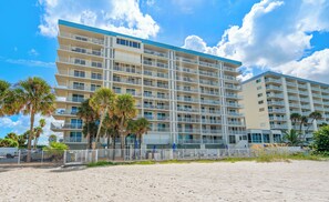 A multi-story hotel with balconies, located near a sandy beach. - New Direct Beachfront 3/2 Upscale, Beachfront Condo, Recliners, Pool, Hot Tub (Indian Rocks Beach)
