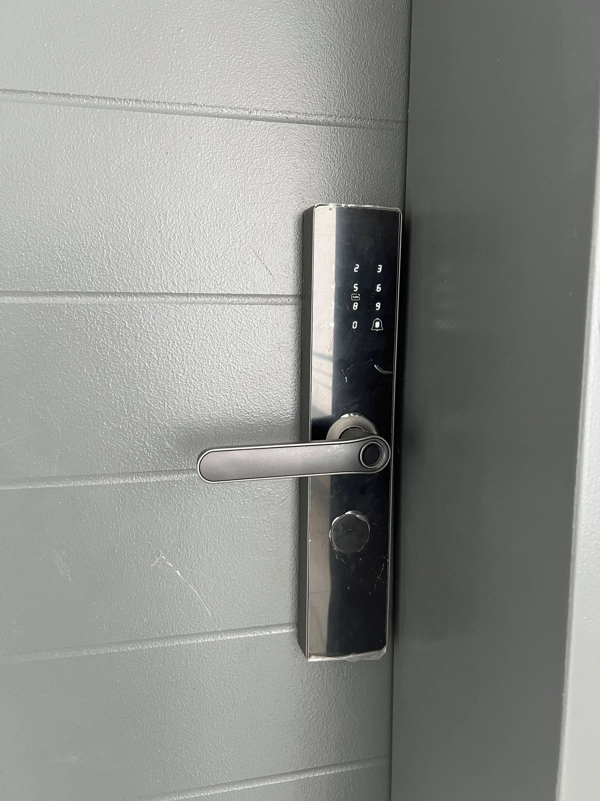 A modern door with a keycard reader and a metallic handle.