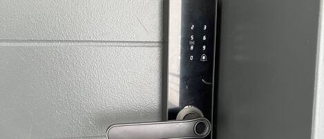 A modern door with a keycard reader and a metallic handle.
