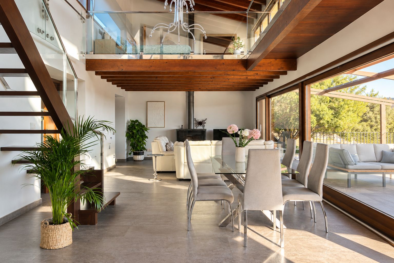 Un interior moderno con una escalera, un comedor y una sala de estar con vistas.