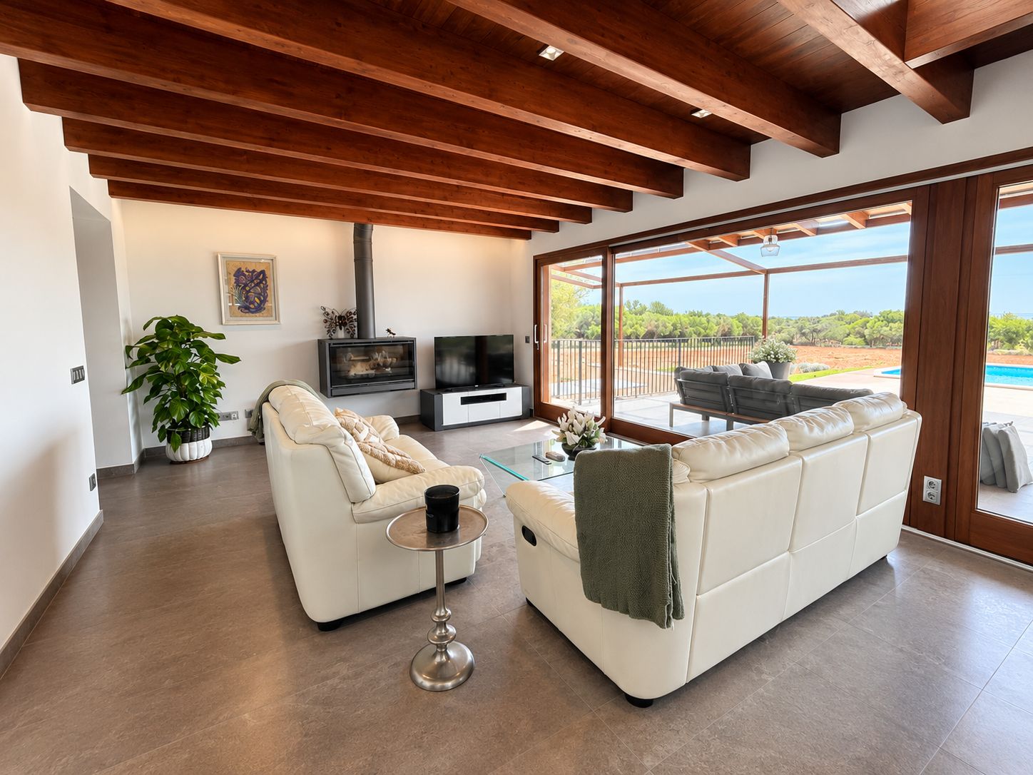 Un salon moderne doté d’une cheminée, d’un canapé, d’une table basse et d’une grande fenêtre donnant sur l’extérieur.