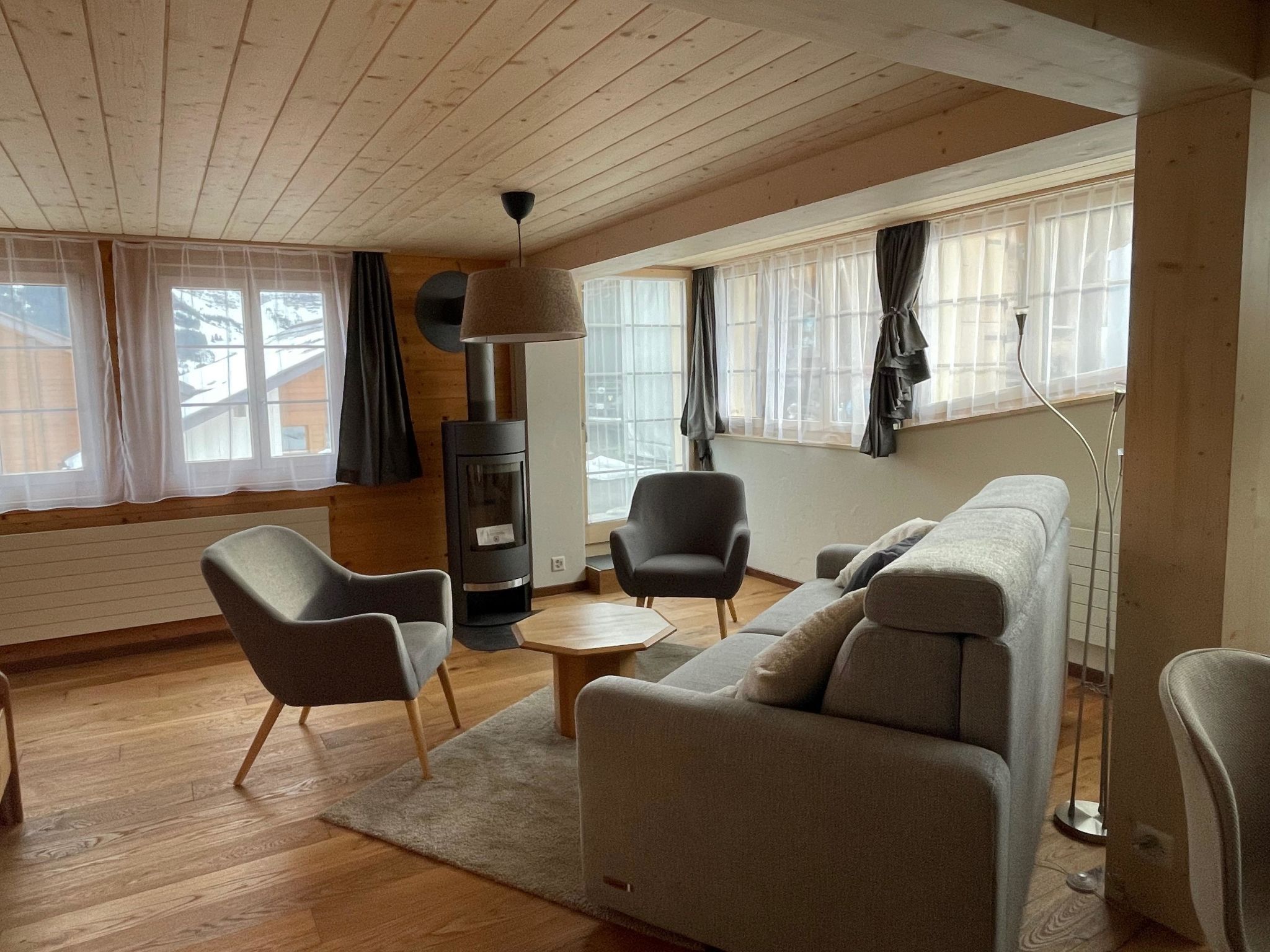 A cozy living room with a sofa, armchairs, a coffee table, and a fireplace.