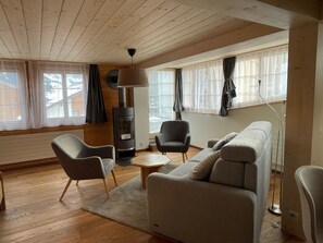 A cozy living room with a sofa, armchairs, a coffee table, and a fireplace. - Grabemattli Appartement/Fewo, Dusche, WC, 1 Schlafraum 2.5-Zimmerwohnung by Interhome (Adelboden)