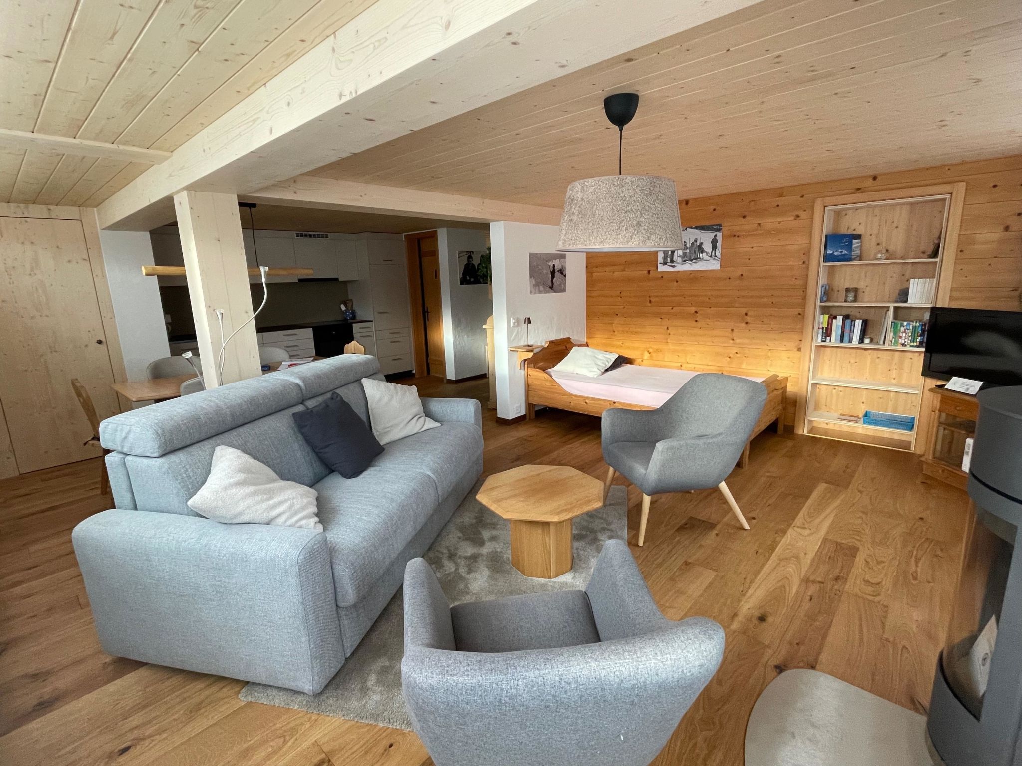 Un salon moderne avec un canapé, des fauteuils, une table basse et un téléviseur.