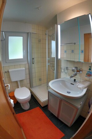 Ein kleines Badezimmer mit Toilette, Dusche und Waschbecken.