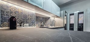 A modern kitchen with patterned tiles, a coffee machine, and a sink.