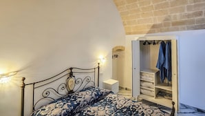 Ein Schlafzimmer mit Bett, Kleiderschrank und Fernseher.